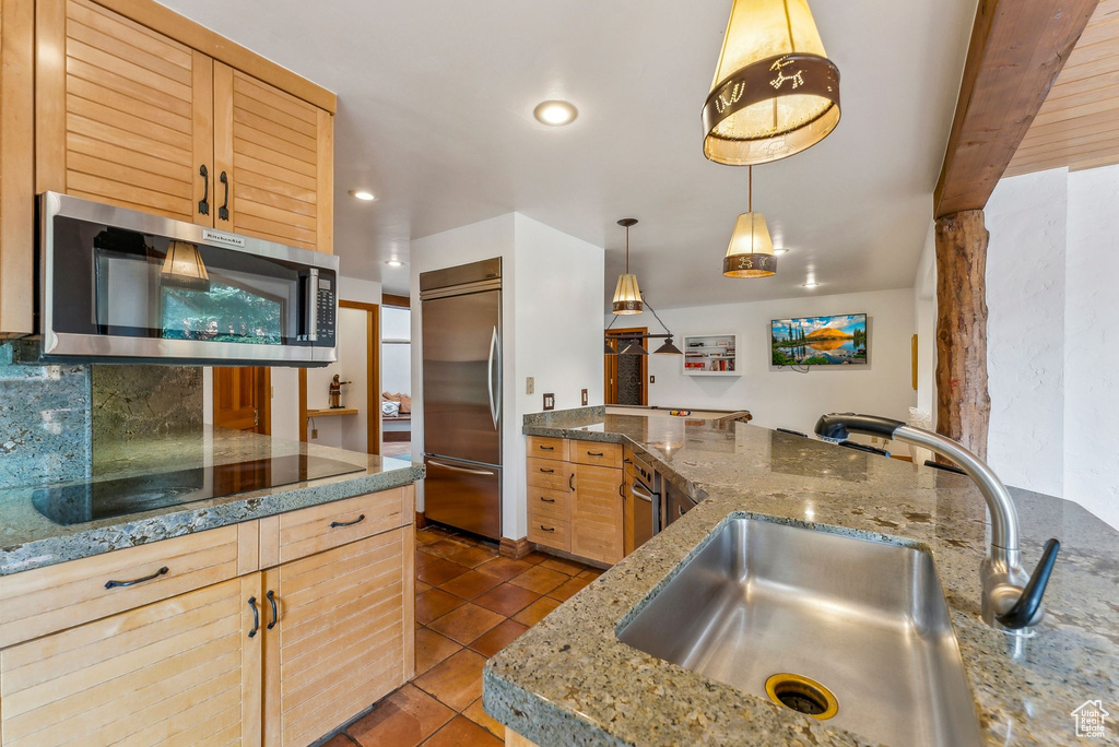 Kitchen featuring recessed lighting, a sink, backsplash, appliances with stainless steel finishes, and dark tile patterned flooring