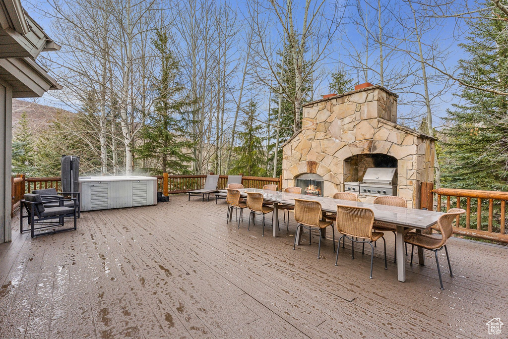 Wooden terrace featuring area for grilling and outdoor dining space