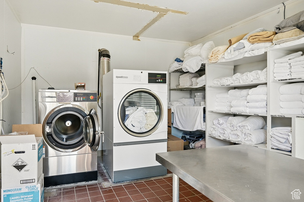 Laundry area with dark tile patterned flooring and washer and clothes dryer