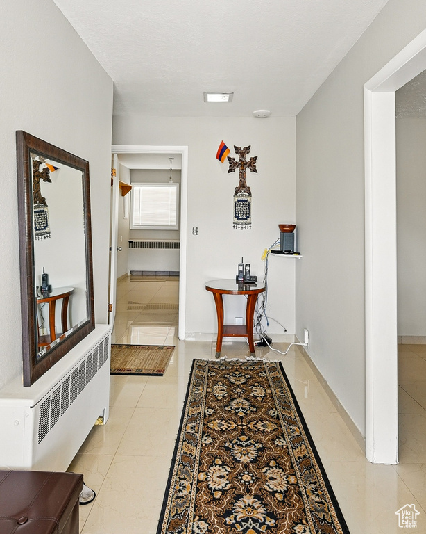 Hallway with radiator and baseboards