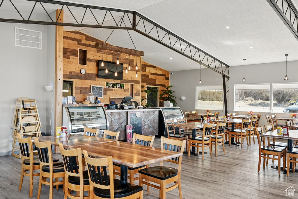 Dining area featuring recessed lighting, wooden walls, lofted ceiling, and wood finished floors