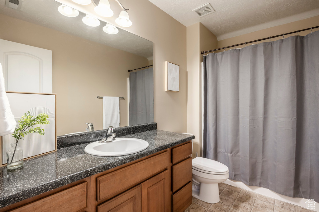 Full bath featuring vanity, a shower with shower curtain, toilet, and visible vents
