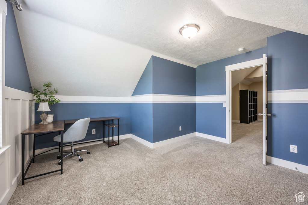 Office featuring carpet floors, a textured ceiling, vaulted ceiling, and baseboards
