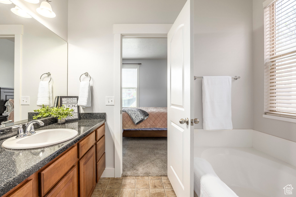 Ensuite bathroom featuring vanity, a bath, and ensuite bath
