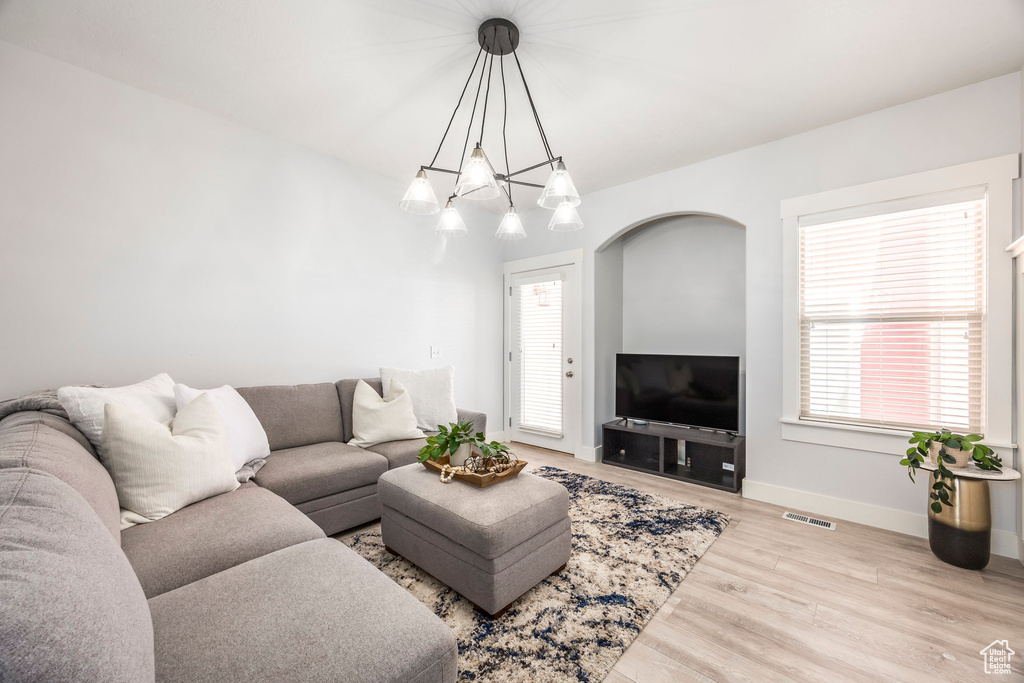 Living area featuring baseboards, visible vents, a healthy amount of sunlight, and wood finished floors