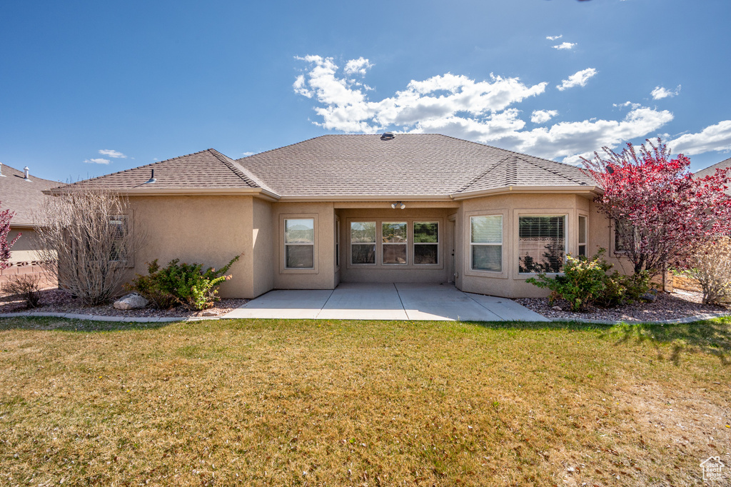 Back of property featuring a yard, a patio area, and stucco siding