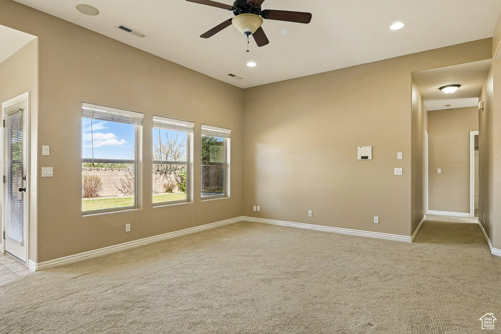 Unfurnished room featuring ceiling fan, visible vents, baseboards, light carpet, and recessed lighting