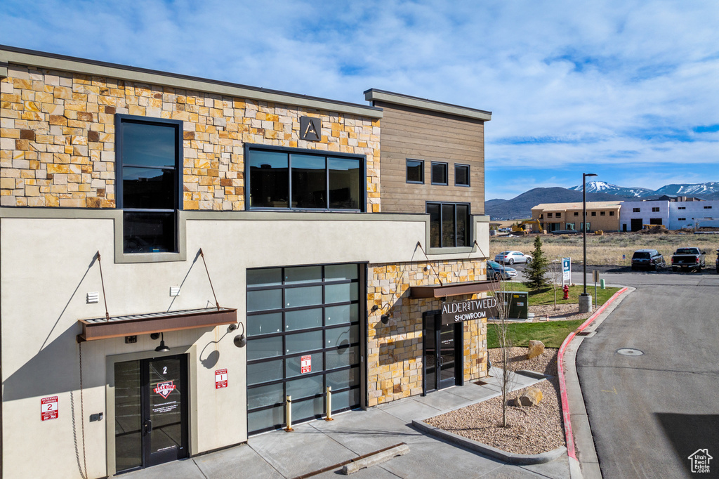 Modern home featuring stucco siding, a mountain view, and stone siding