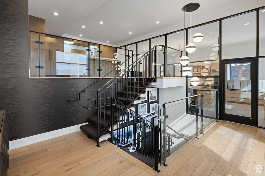 Stairs with recessed lighting and hardwood / wood-style floors