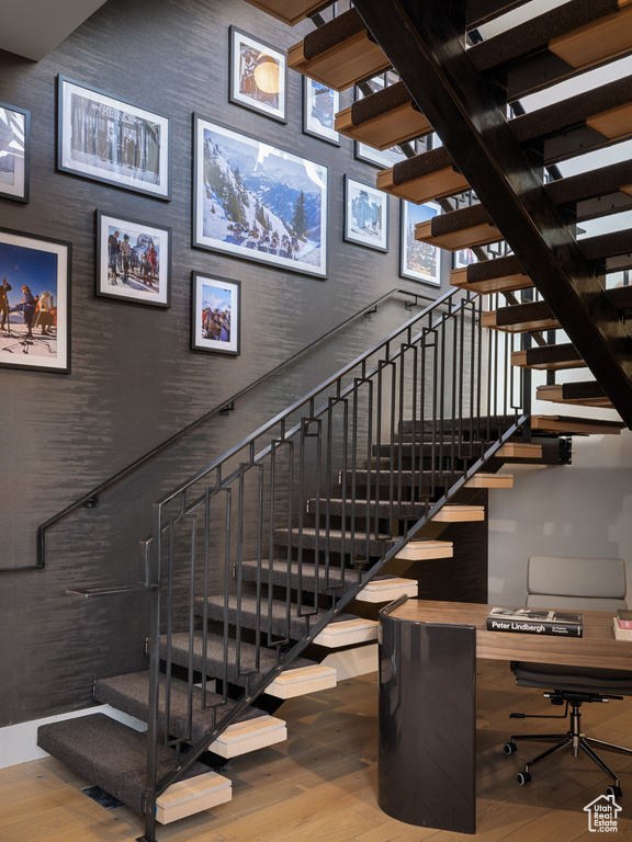 Stairway featuring wood finished floors