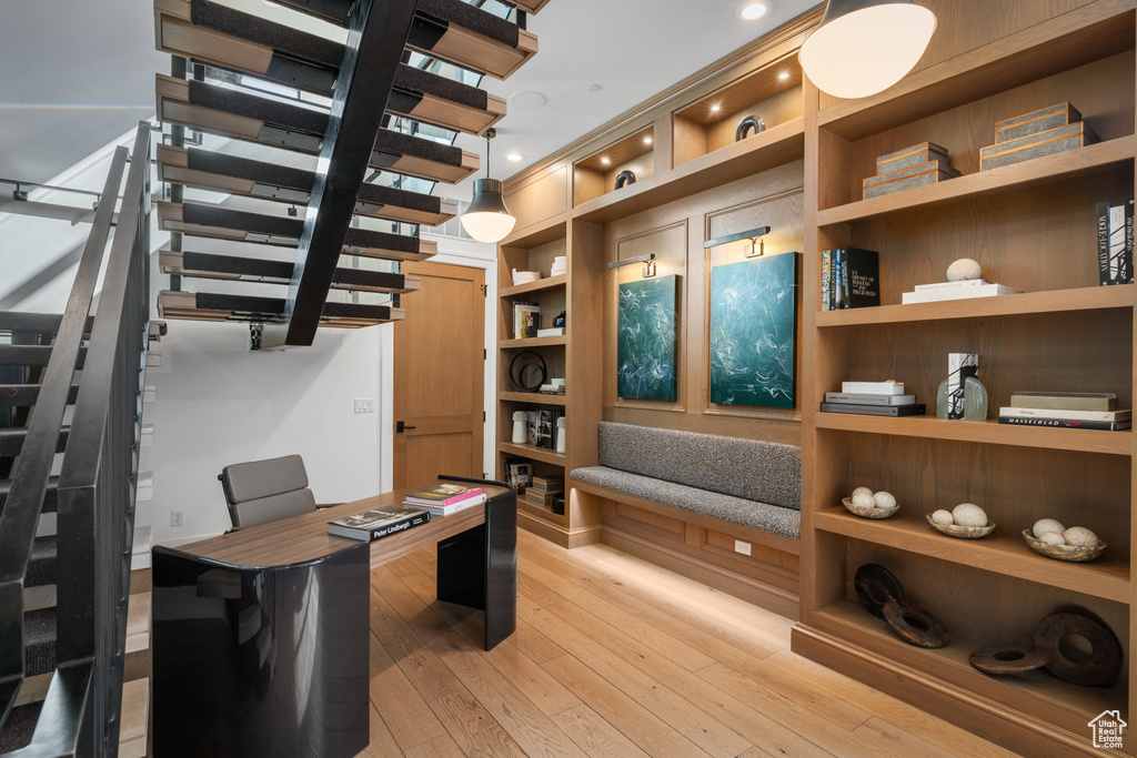 Office space with recessed lighting, light wood-style floors, and built in features