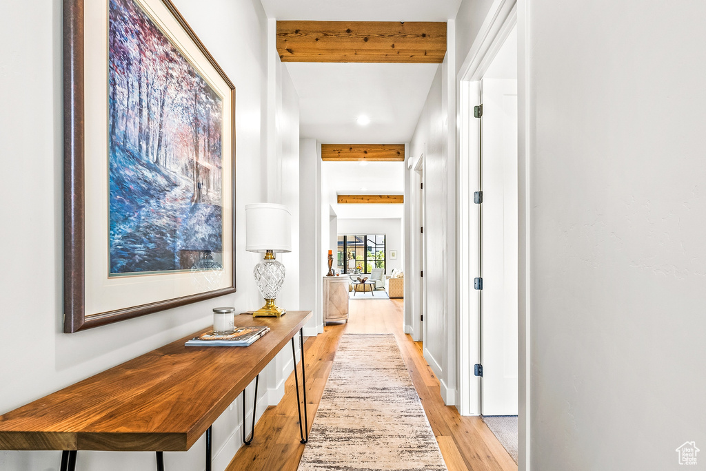 Hallway with recessed lighting, beam ceiling, and light wood-style floors
