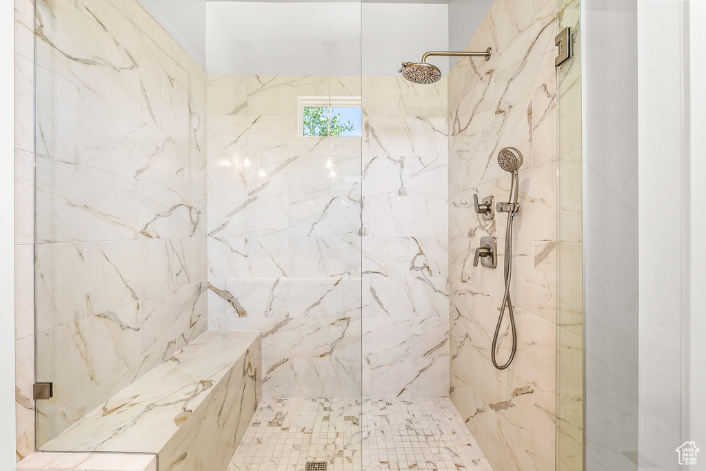 Full bath featuring a marble finish shower