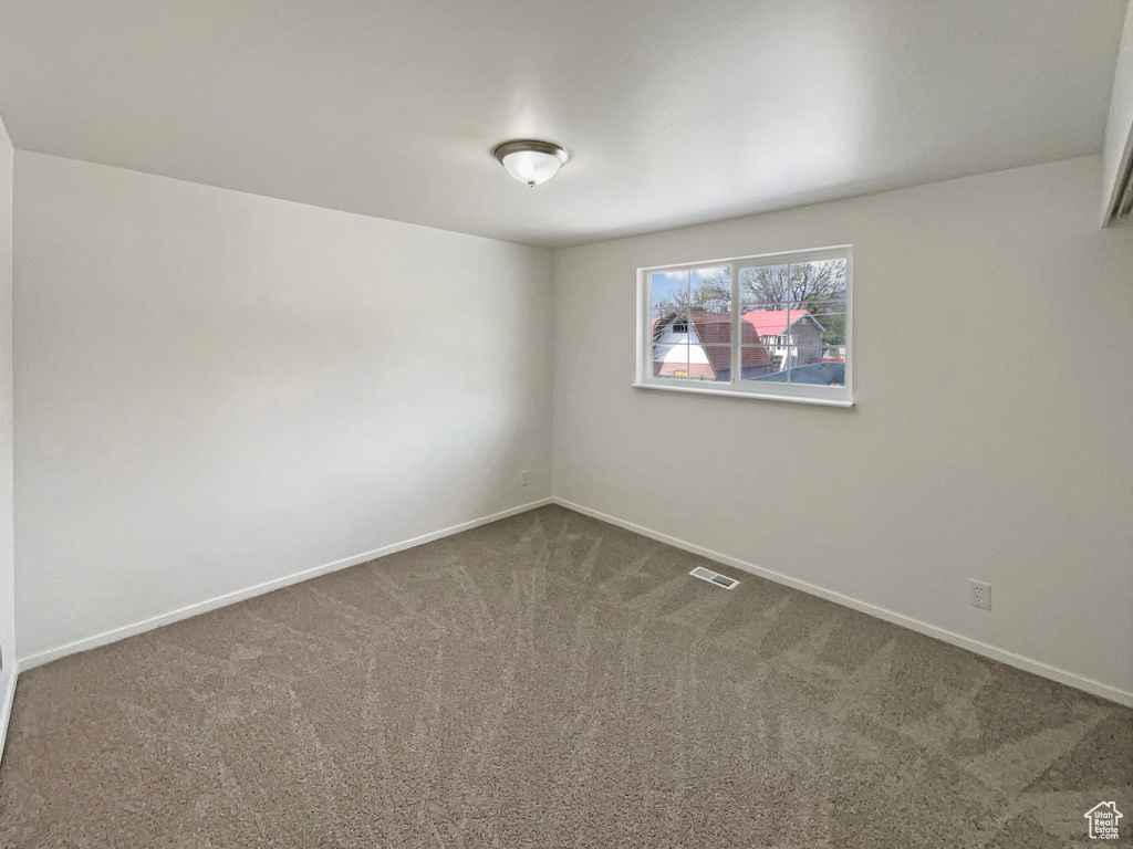 Unfurnished room with baseboards, carpet, and visible vents