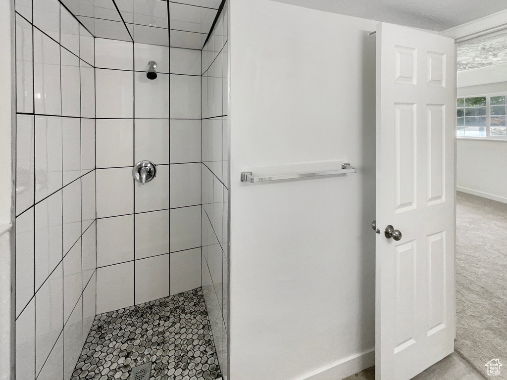 Bathroom featuring baseboards and tiled shower