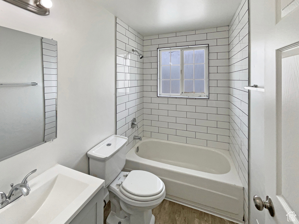Full bathroom with toilet, tub / shower combination, wood finished floors, and vanity