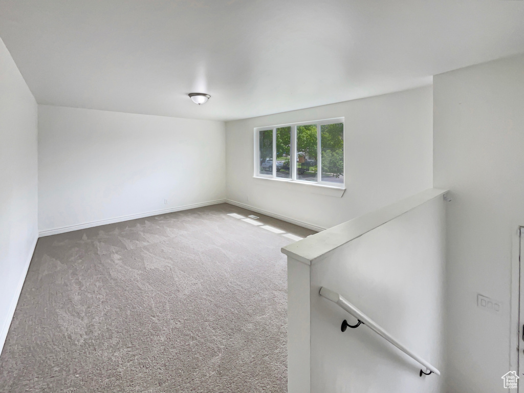 Carpeted empty room featuring baseboards
