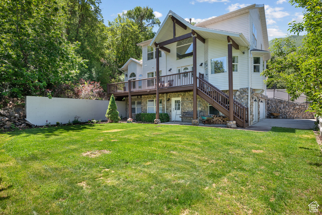 View of front facade featuring a wooden deck, stairs, and stone siding