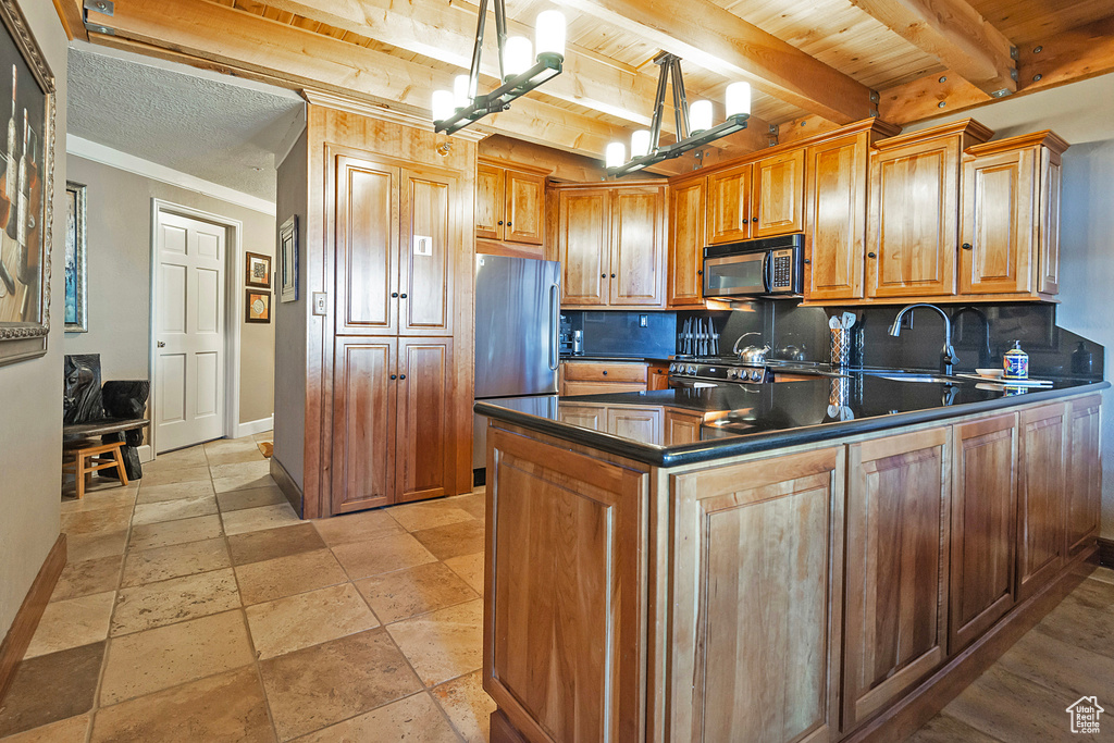 Kitchen with beam ceiling, freestanding refrigerator, baseboards, dark countertops, and decorative backsplash
