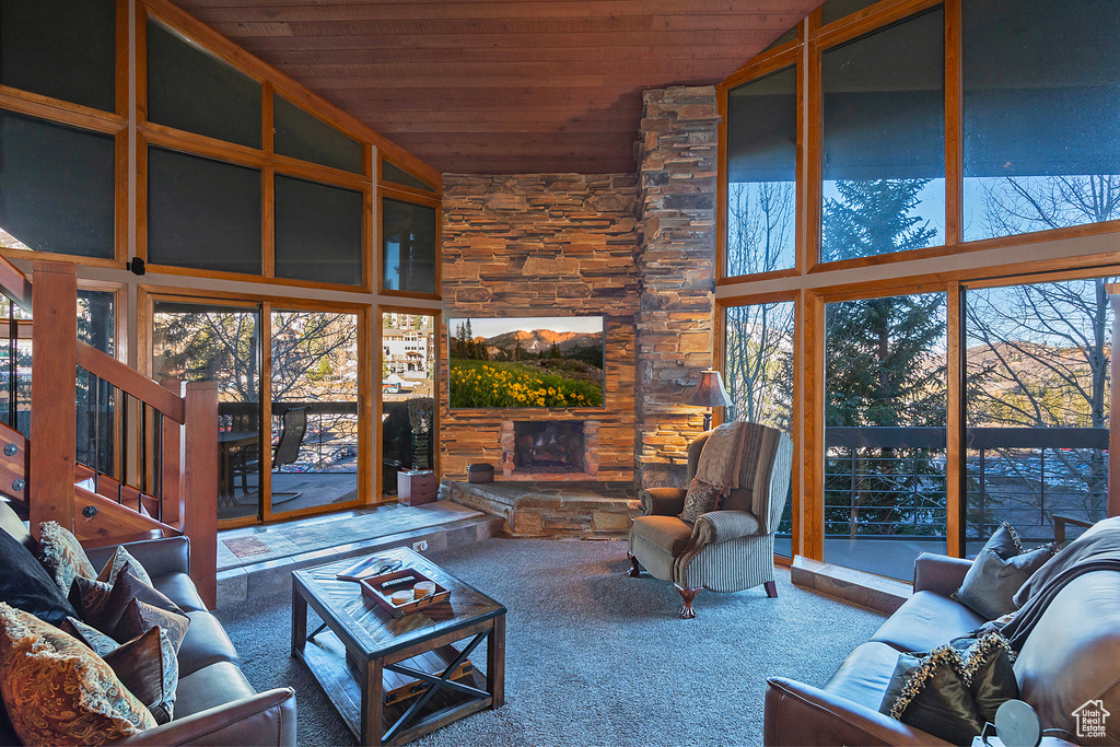 Carpeted living room with wood ceiling, a fireplace, and stairs