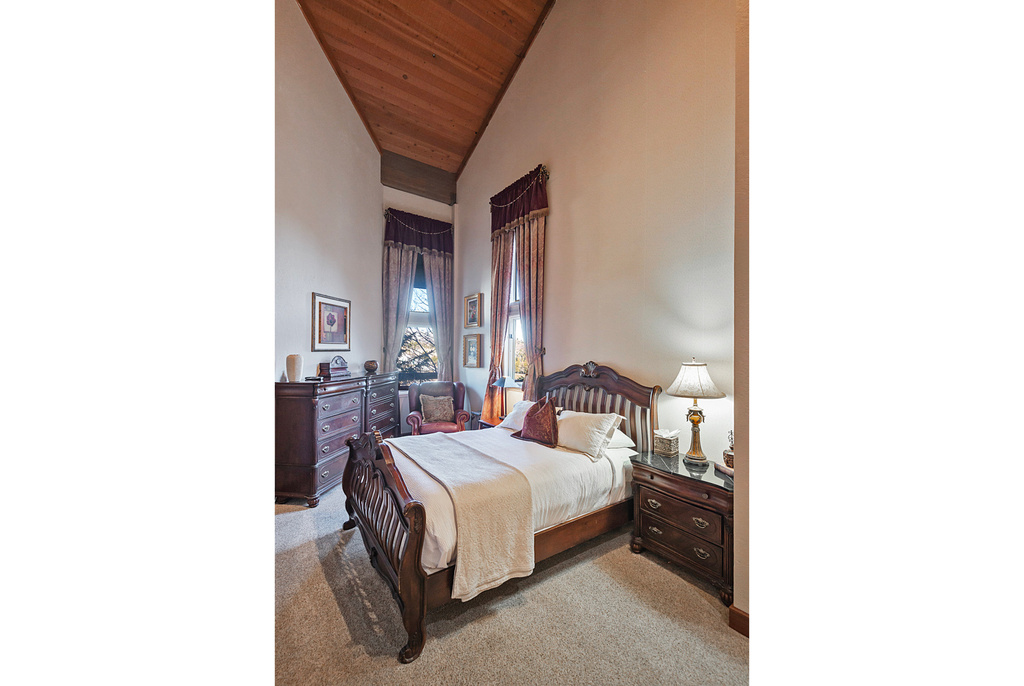 Carpeted bedroom featuring wooden ceiling and high vaulted ceiling