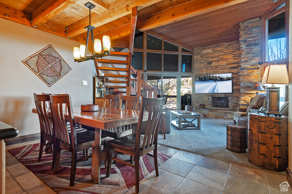 Dining area with a fireplace, stairway, wooden ceiling, and beam ceiling