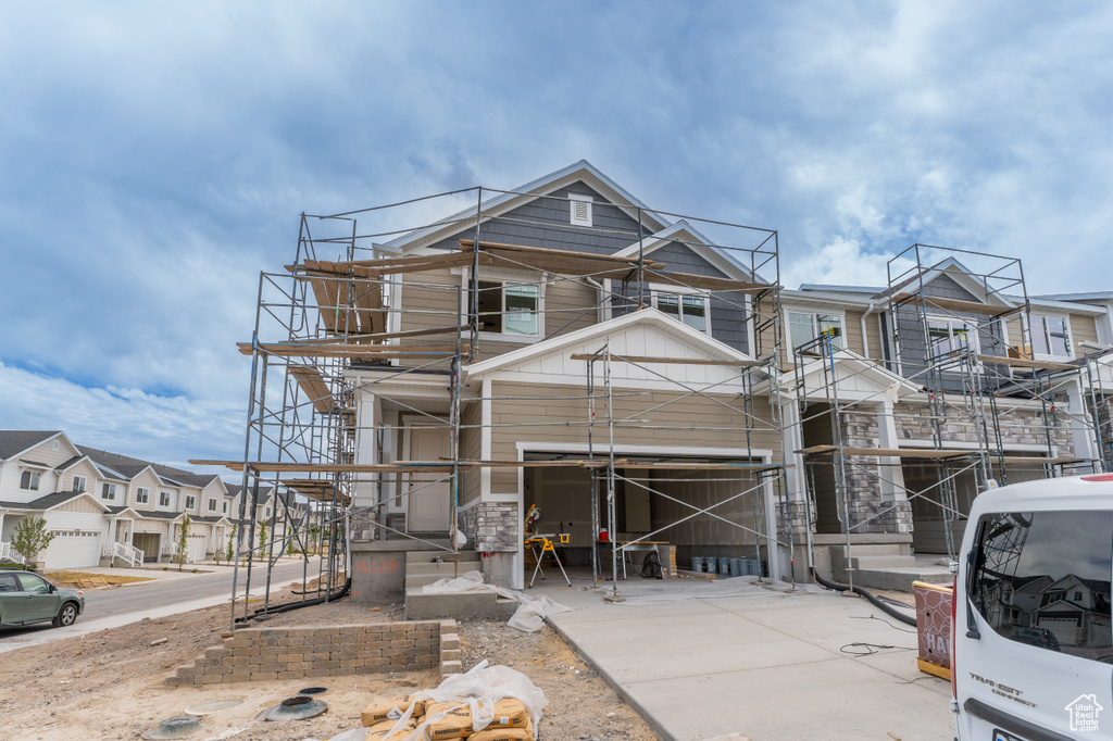 View of front facade featuring board and batten siding, a residential view, and stairway