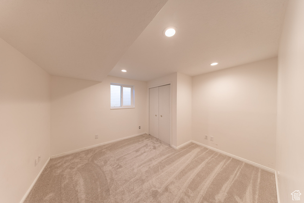Below grade area with light carpet, recessed lighting, and baseboards