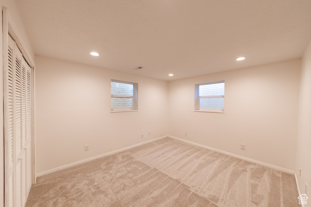 Unfurnished bedroom featuring light colored carpet, recessed lighting, baseboards, and a closet