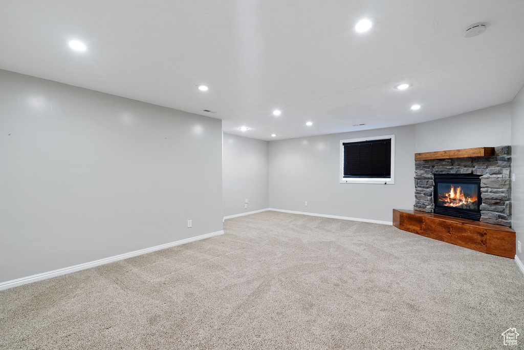 Unfurnished living room featuring baseboards, recessed lighting, and light colored carpet