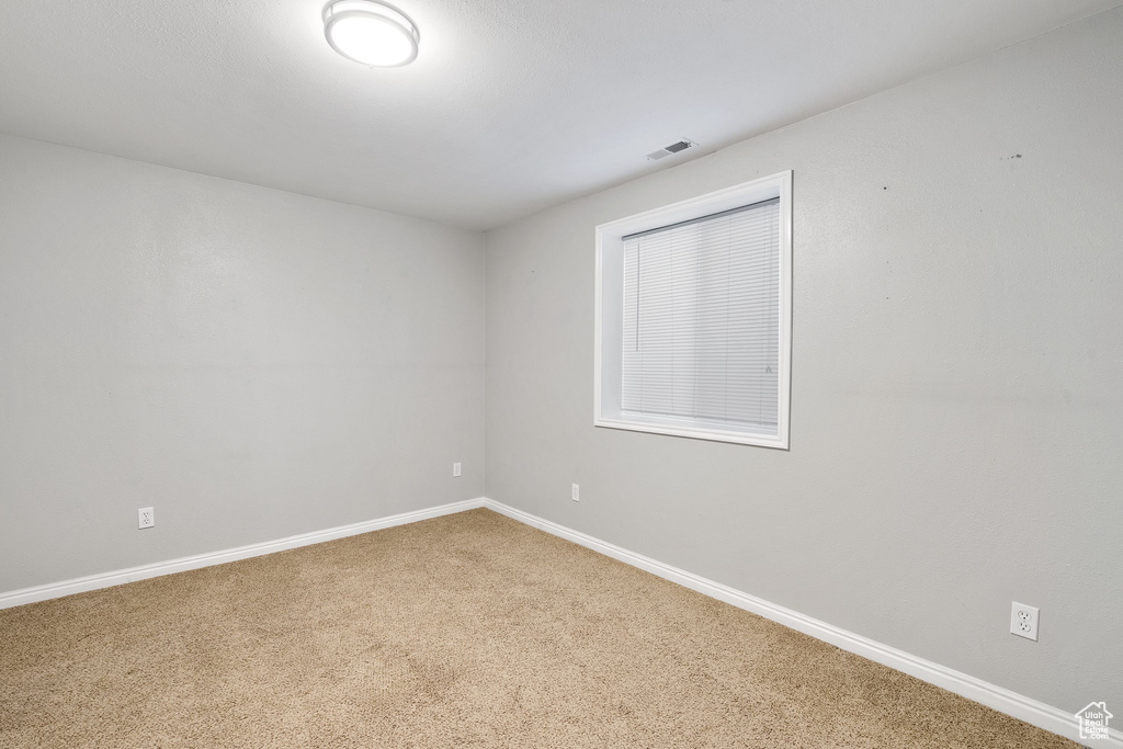 Spare room with carpet floors, visible vents, and baseboards