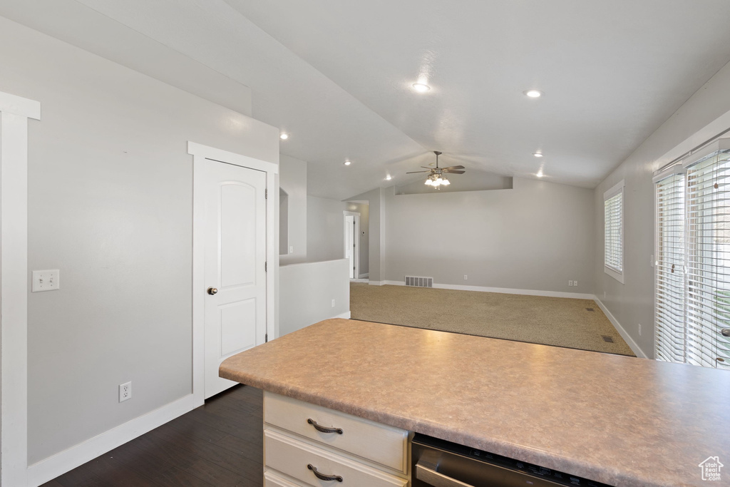 Kitchen featuring lofted ceiling, light countertops, visible vents, a ceiling fan, and baseboards