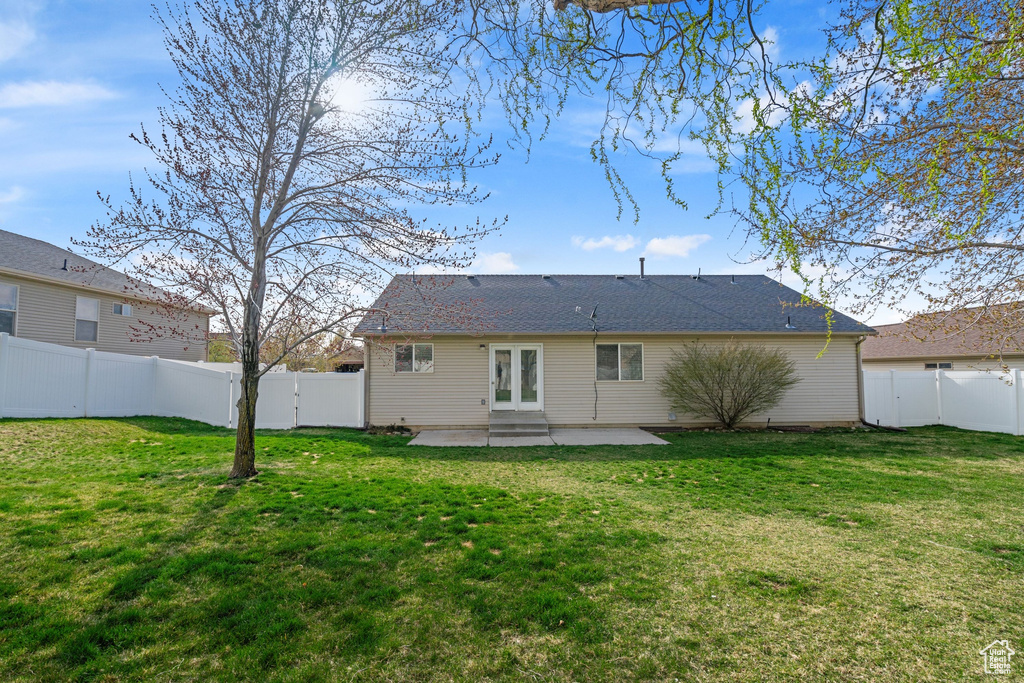 Back of house with a fenced backyard, a yard, and a patio