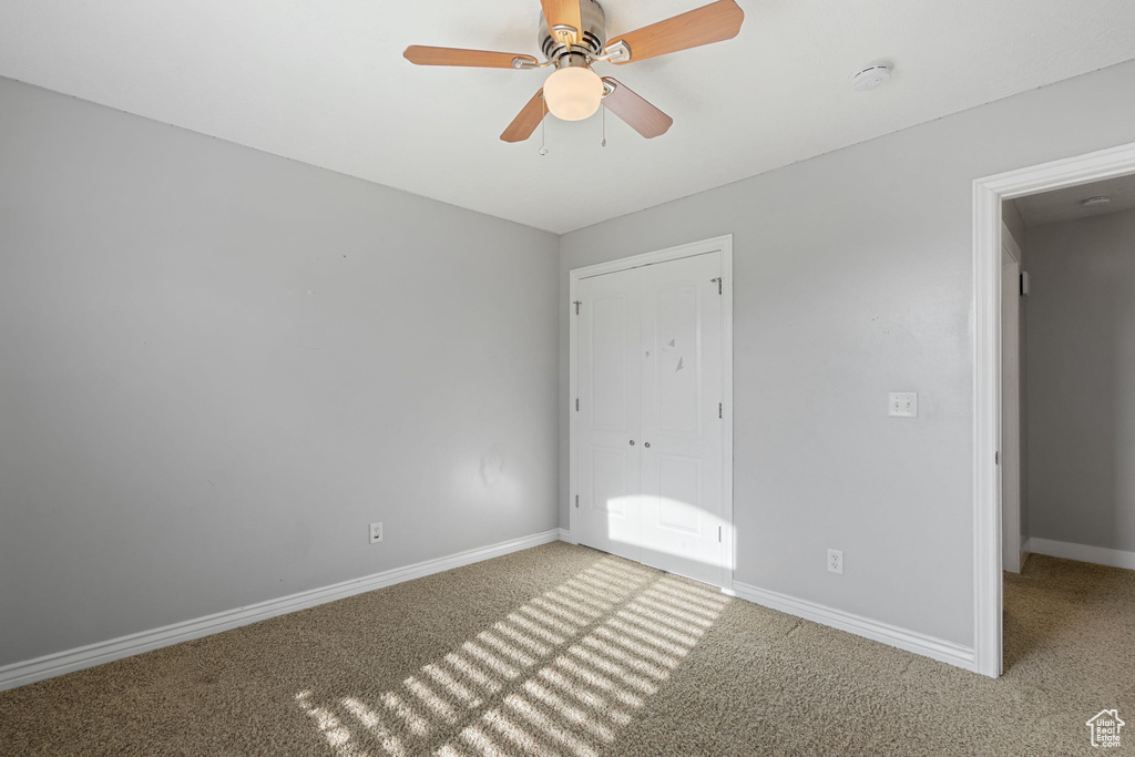 Unfurnished bedroom featuring baseboards, carpet floors, and ceiling fan