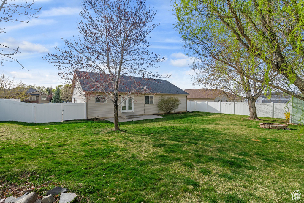 View of yard featuring a fenced backyard, a patio area, an outdoor fire pit, and entry steps