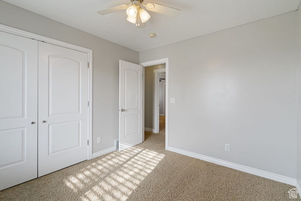 Unfurnished bedroom with a ceiling fan, baseboards, carpet floors, and a closet
