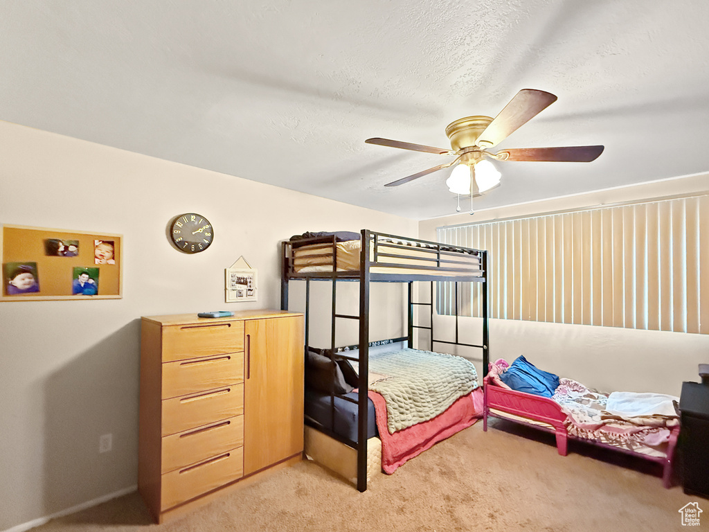 Bedroom with a ceiling fan and light carpet