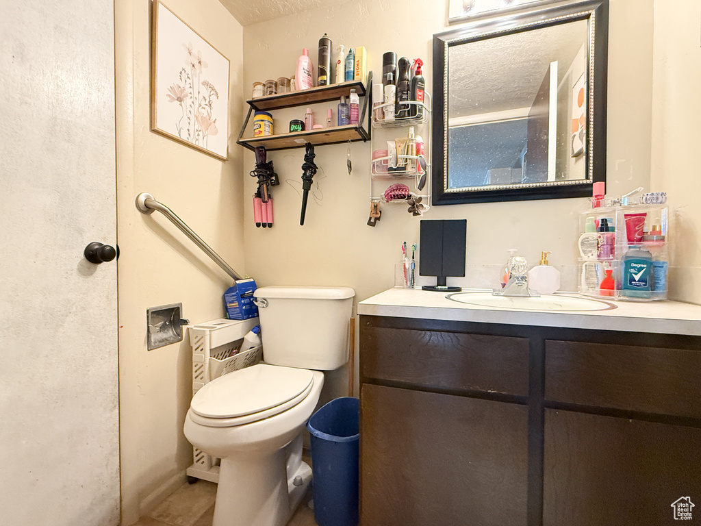 Bathroom featuring vanity, tile patterned flooring, and toilet