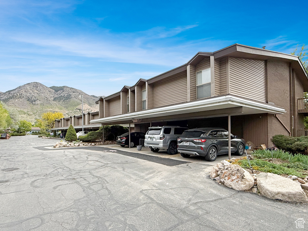 View of side of home with covered parking, a mountain view, and brick siding