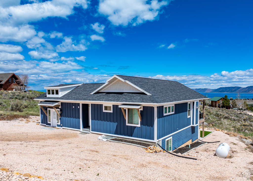 View of front of property featuring board and batten siding, roof with shingles, and a mountain view