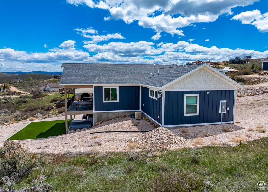 View of front of property featuring board and batten siding and roof with shingles