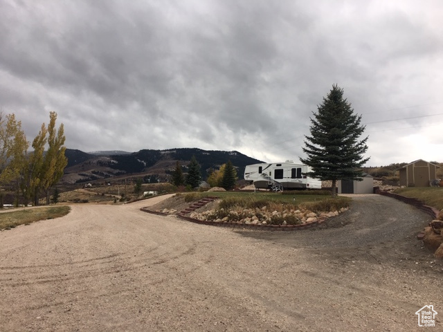 View of road with a mountain view and dirt driveway