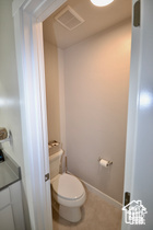 Bathroom featuring toilet, baseboards, and visible vents