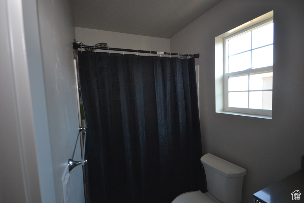 Full bathroom featuring toilet and a shower with curtain