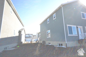 View of side of home featuring stucco siding and fence