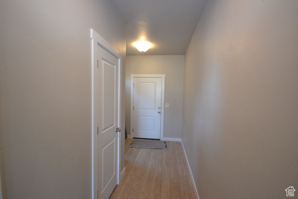 Corridor with baseboards and light wood finished floors