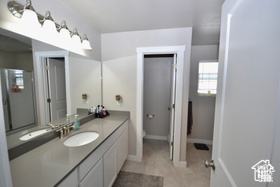 Bathroom featuring vanity, baseboards, tile patterned flooring, and toilet