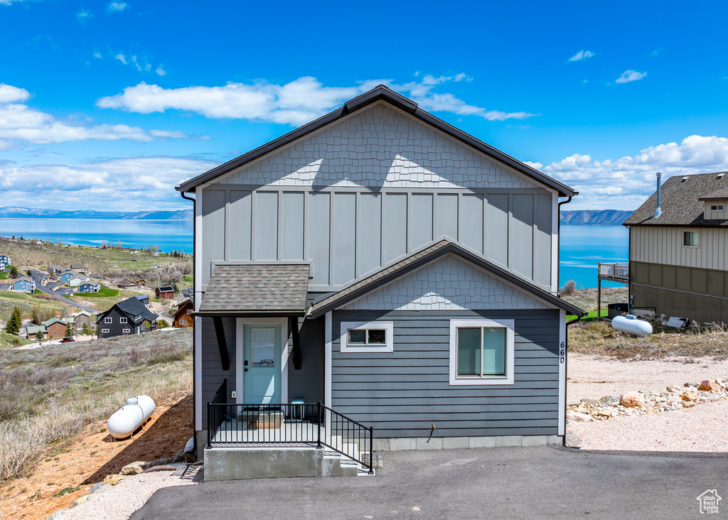 View of front facade featuring board and batten siding and a water view