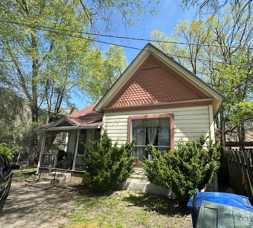 View of front facade featuring a porch and fence