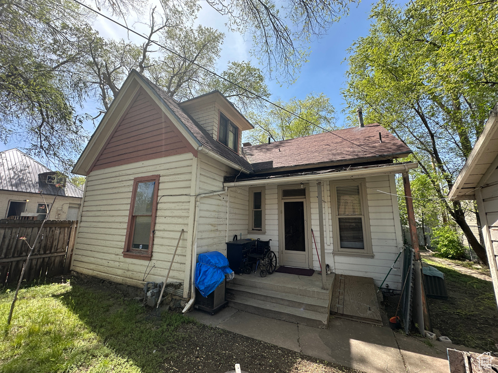 Back of property with fence and roof with shingles